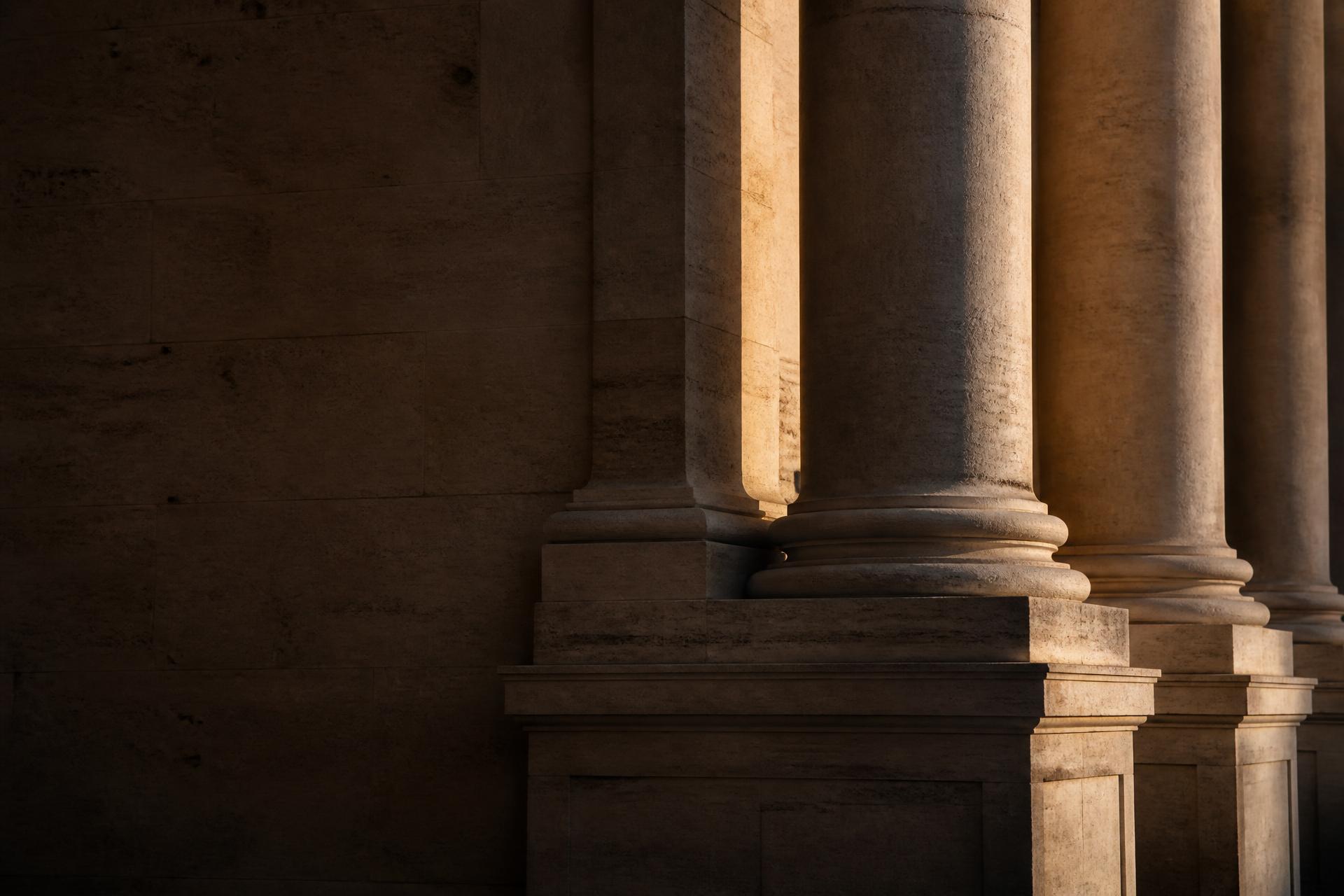 Sunlit limestone colonnade in deep afternoon shadow